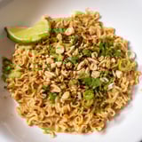 A vibrant bowl of Instant Peanut Thai Sauce Noodles, garnished with fresh cilantro and crunchy peanuts.