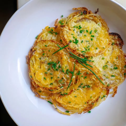 Golden, crispy onion cheese chips piled on a white plate, ready for dipping and enjoying.