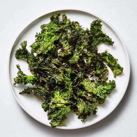 Sea salt and garlic seasoned kale chips fresh from the oven, ready to enjoy as a light snack.