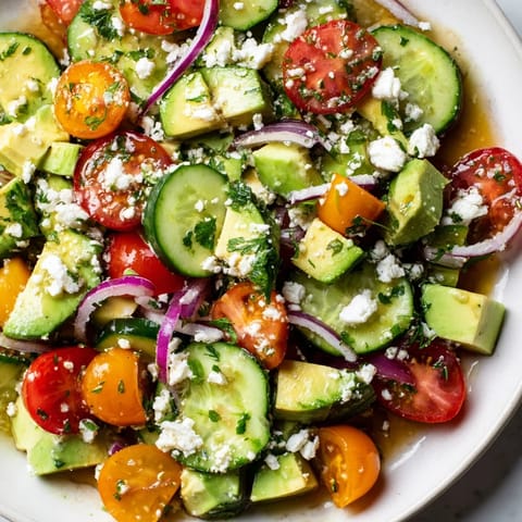 Bright, fresh Fresh Cucumber Tomato Avocado Salad with Feta, drizzled with zesty lemon vinaigrette.