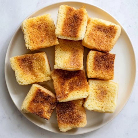 Warm, toasted sheet pan English muffins, showing off their perfect nooks and crannies.