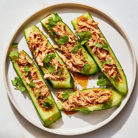 Savory Whole Cucumber Logan Salad with shredded chicken, dressed in a flavorful sauce, ready to eat.