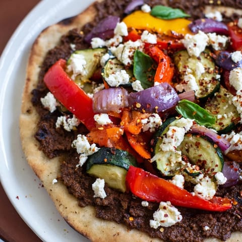 Mediterranean-style Naan Bread Pizza featuring vibrant roasted vegetables and creamy, crumbled feta cheese.