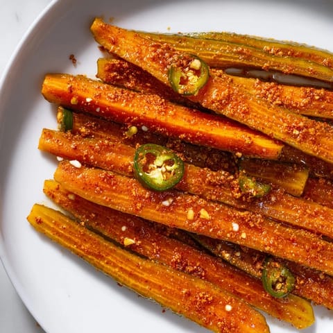 Taco Pickles marinating in seasoned brine, with vibrant spices visible, served alongside nachos for a zesty party snack.  