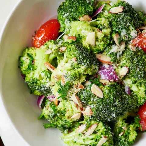 Hearty Garlic Parmesan Broccoli Salad with crunchy slivered almonds and fresh parsley, served chilled as a nutritious side dish.  