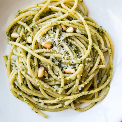 Warm Creamy Sunflower Seed Pesto Pasta tossed with a silky sauce, finished with grated Parmesan and a lemon wedge.