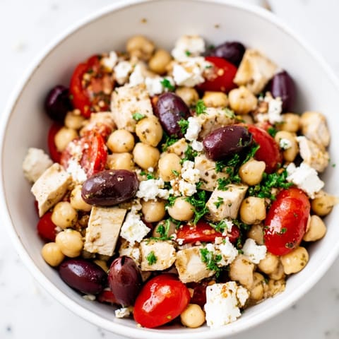 Perfectly portioned for four, this Mediterranean Chickpea Chicken Salad features briny Kalamata olives and fresh parsley over diced cucumber and tomatoes.