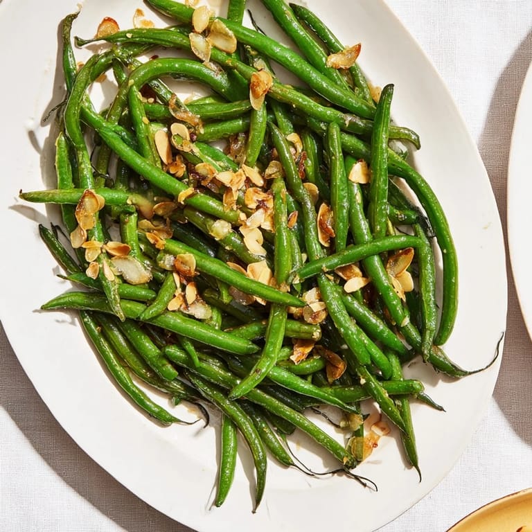 Tender, bright-green Sautéed Green Beans with Garlic and Almonds, a healthy and flavorful vegetarian dish option.