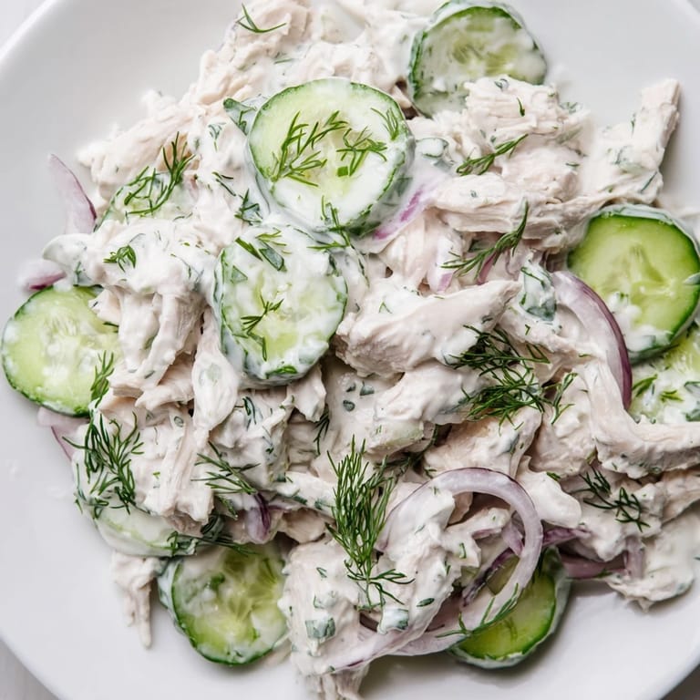 Easy high-protein Creamy Cucumber Chicken Salad garnished with green onions, perfect for a light summer lunch or meal prep.